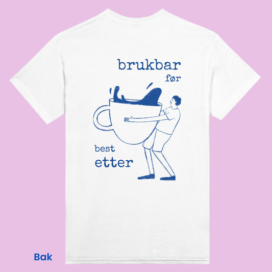 Retro hvit t-skjorte med blå illustrasjon av mann som bærer en stor kopp kaffe. Med teksten 'brukbar før, best etter'. Perfekt norsk inspirert plagg som matcher alle antrekk. 