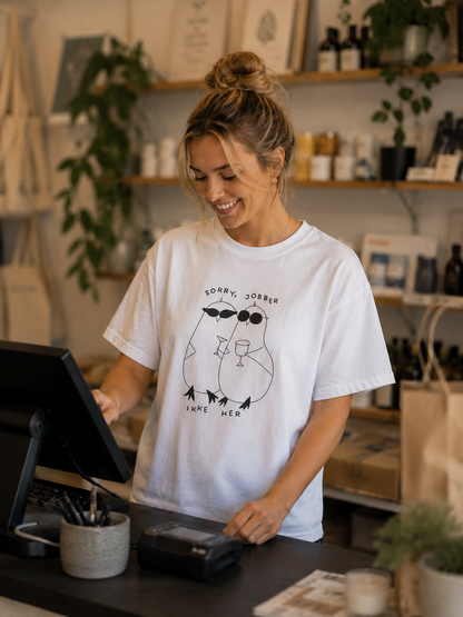 Hvit, minimal, men morsom gave til kollega. En t-skjorte med trykk som skiller seg ut. To håndtegnede duer og teksten "sorry, jobber ikke her". 
