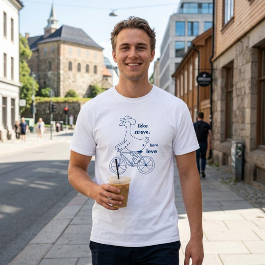 hvit t-skjorte med teksten “ikke streve, bare leve”. Morsom håndtegnet gås på sykkel, med cowboy hatt og boots.